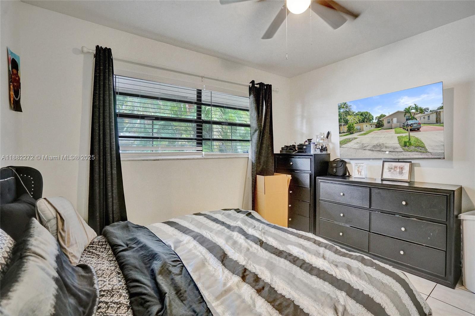 5606 Hayes Street, Unit 2 Hollywood, FL 33021 - Photo 6 of 20 a bedroom with a bed and a flat tv screen on dresser