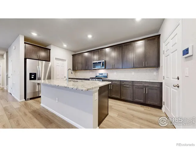 a kitchen with granite countertop a sink and a stove top oven