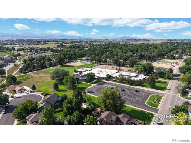 an aerial view of a house with a swimming pool a yard and mountain view in back