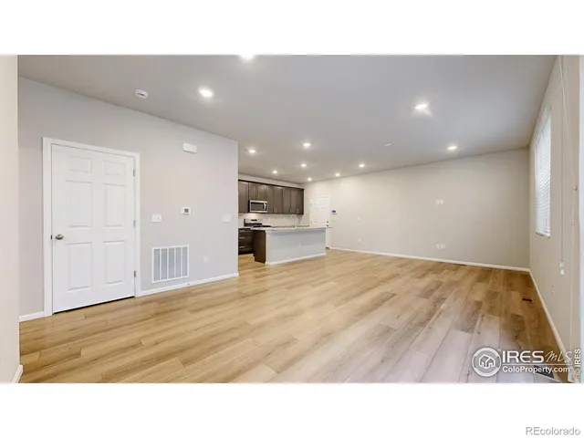 a room with kitchen island sink and refrigerator