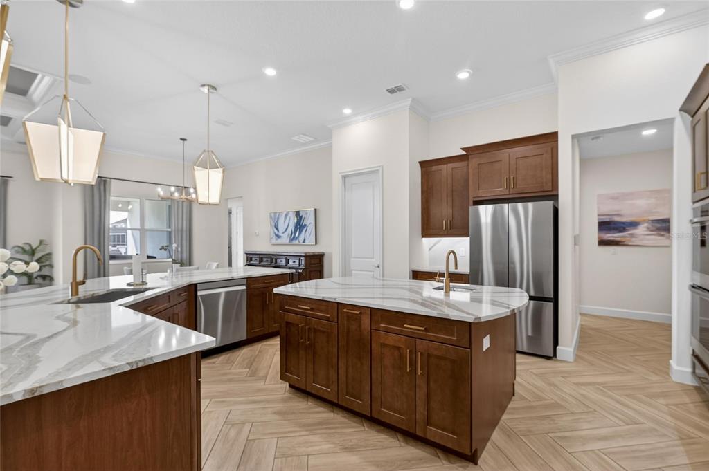 914 Signet Drive Apollo Beach, FL 33572 - Photo 26 of 100 a large kitchen with kitchen island a sink stainless steel appliances and cabinets