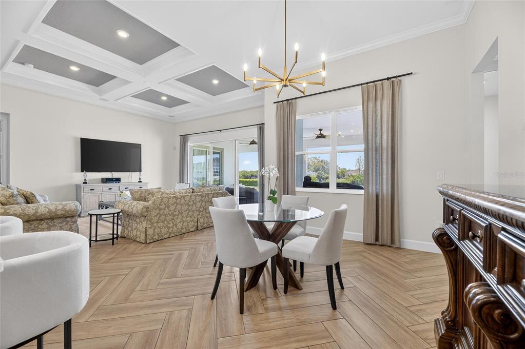 914 Signet Drive Apollo Beach, FL 33572 - Photo 28 of 100 a dining room with furniture a flat screen tv and a chandelier