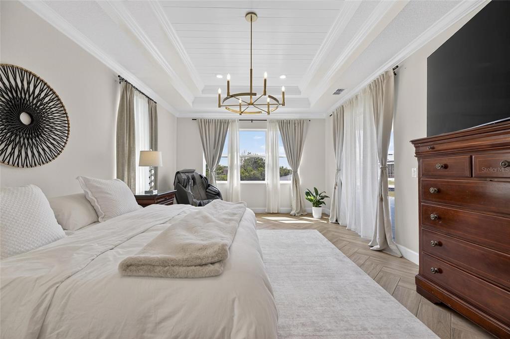 914 Signet Drive Apollo Beach, FL 33572 - Photo 30 of 100 a spacious bedroom with a bed and a chandelier