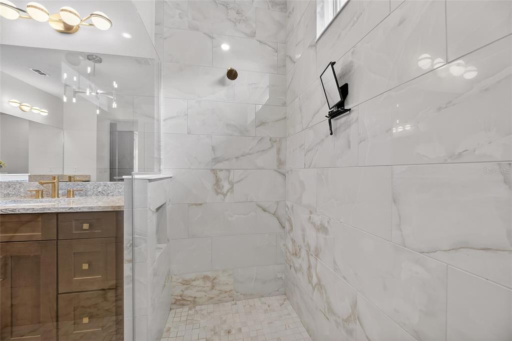 914 Signet Drive Apollo Beach, FL 33572 - Photo 35 of 100 a bathroom with a granite countertop sink a large mirror and shower