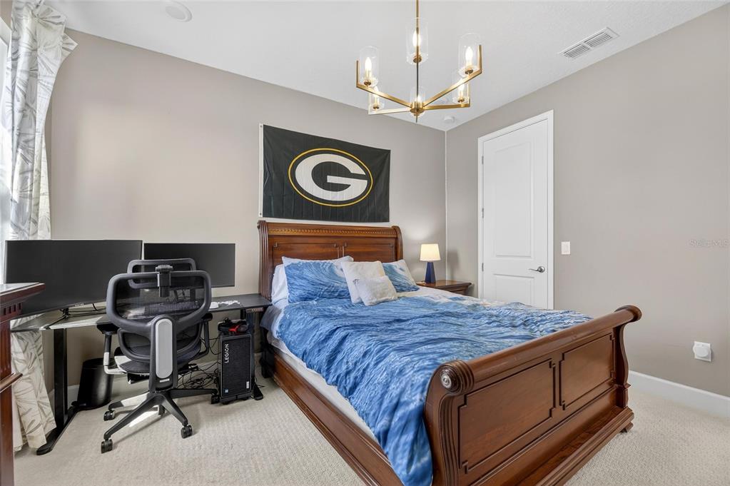 914 Signet Drive Apollo Beach, FL 33572 - Photo 40 of 100 a bedroom with a bed and a chandelier