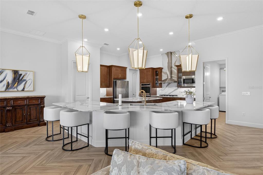 914 Signet Drive Apollo Beach, FL 33572 - Photo 4 of 100 a kitchen with kitchen island stainless steel appliances a dining table chairs sink and stove top oven