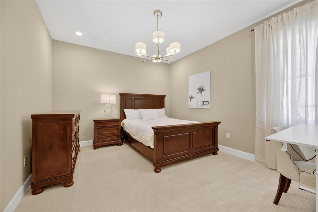 914 Signet Drive Apollo Beach, FL 33572 - Photo 42 of 100 a spacious bedroom with a bed and a chandelier