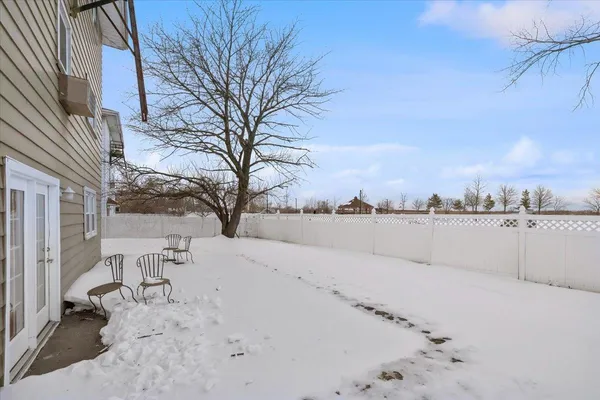 a backyard of a house with large trees and a covered with snow