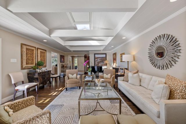 a living room with furniture a fireplace and a chandelier