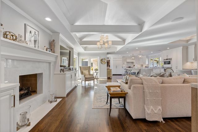 a kitchen with stainless steel appliances kitchen island granite countertop a wooden floor and white cabinets