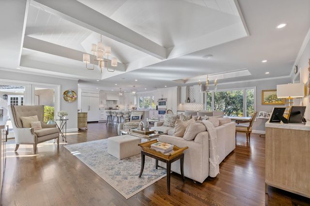 a large white kitchen with a large window and stainless steel appliances