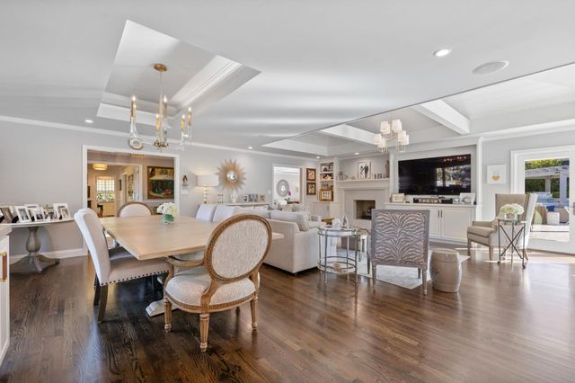 a view of a patio with table and chairs potted plants and floor to ceiling window