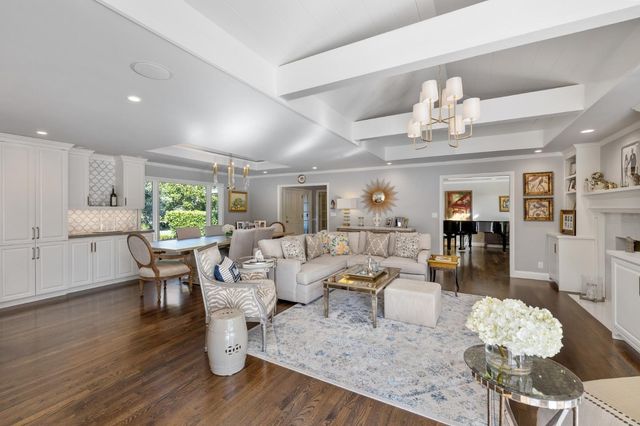 a view of a patio with couches table and chairs with wooden floor and fence