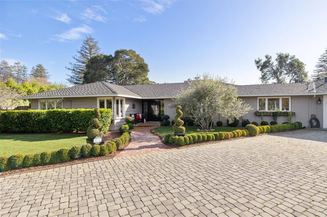 a living room with furniture a flat screen tv and a floor to ceiling window