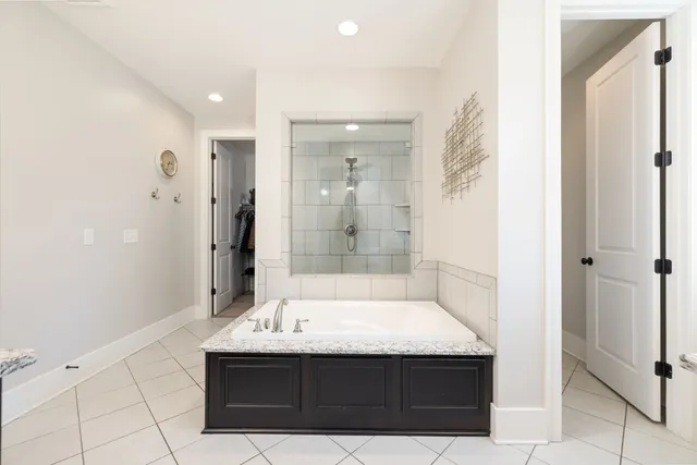a large bathroom with a granite countertop tub sink and shower