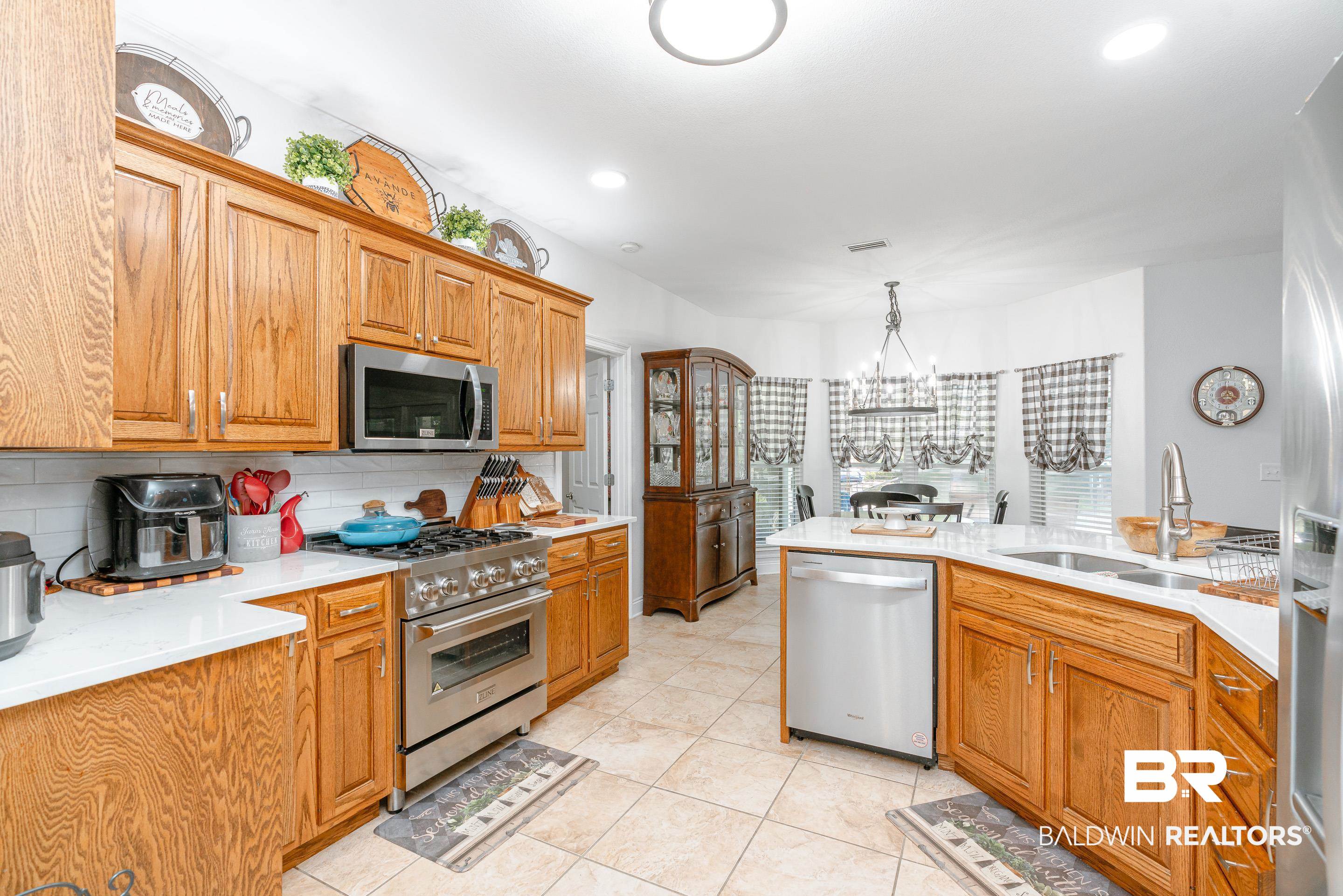 302 Bristol Way Foley, AL 36535 - Photo 10 of 51 Kitchen with light tile patterned flooring, tasteful backsplash, an inviting chandelier, appliances with stainless steel finishes, and sink