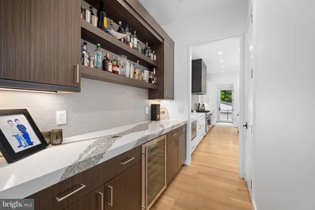 a bed sitting in a spacious bedroom next to a window and a chandelier