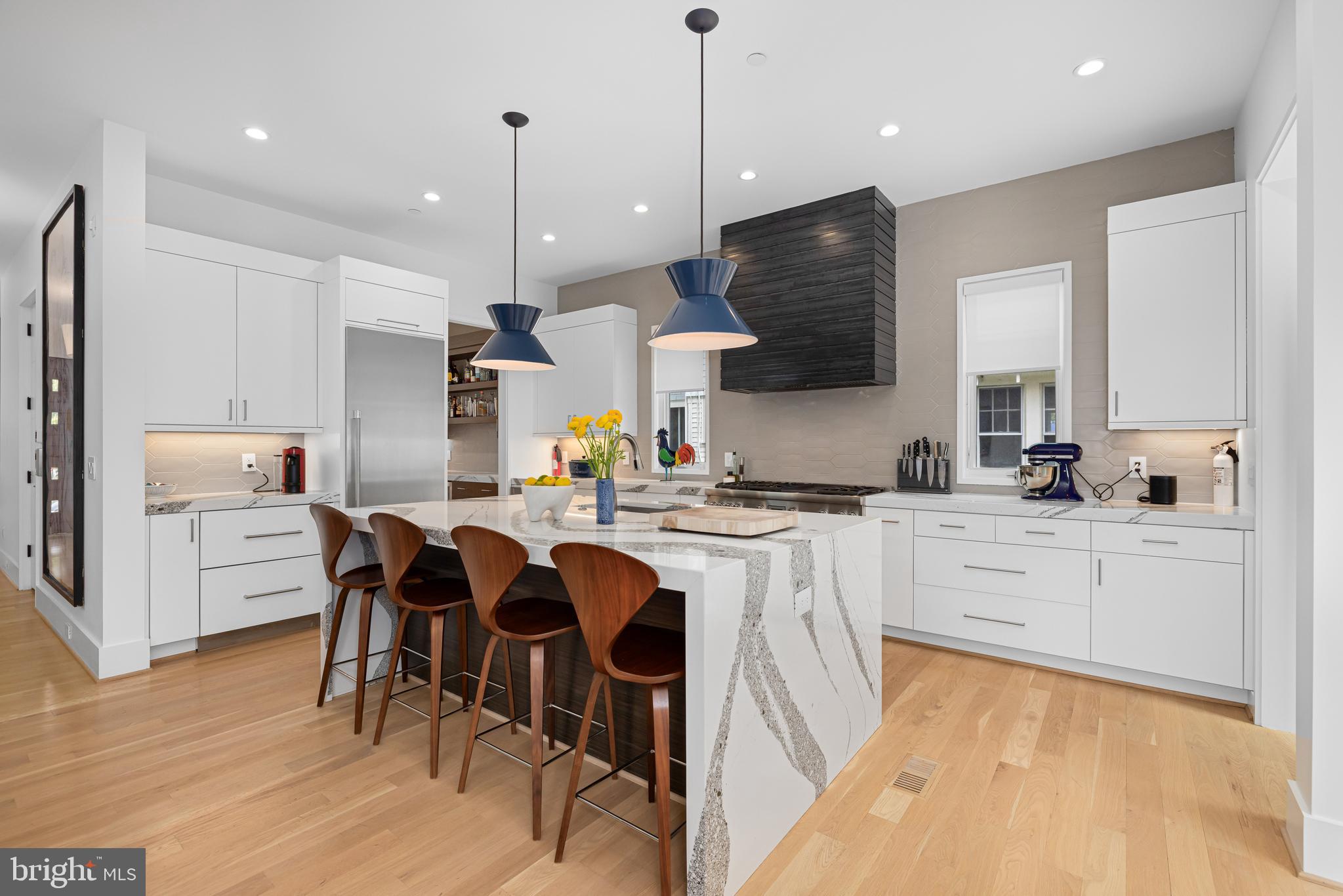 5624 Sherier Place Northwest Washington, DC 20016 - Photo 8 of 60 a kitchen with stainless steel appliances kitchen island granite countertop a stove a sink a refrigerator and white cabinets with wooden floor