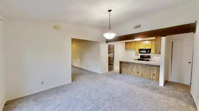 a view of kitchen with refrigerator and window