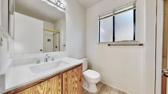 a bathroom with a sink a toilet and a mirror