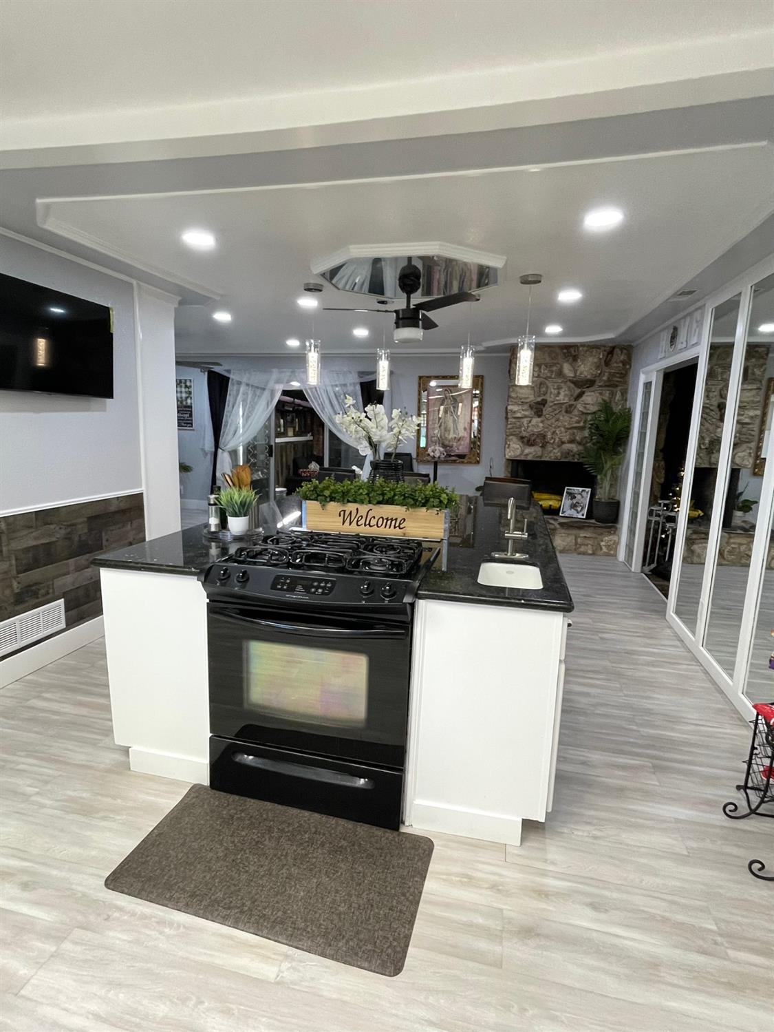 2313 Thomas Street Ceres, CA 95307 - Photo 11 of 35 a kitchen with stainless steel appliances kitchen island granite countertop a stove a sink and a living room with a couch