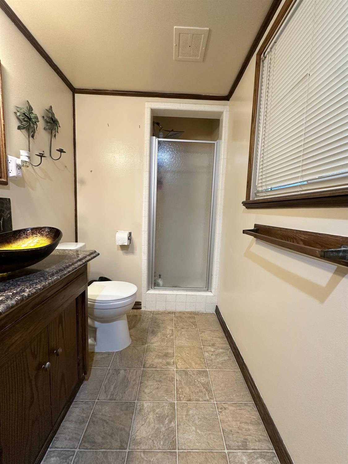 2313 Thomas Street Ceres, CA 95307 - Photo 30 of 35 a bathroom with a granite countertop sink a toilet and a mirror