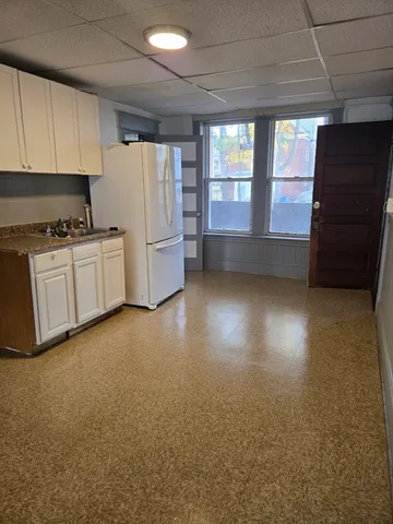a kitchen with a refrigerator a stove and a window