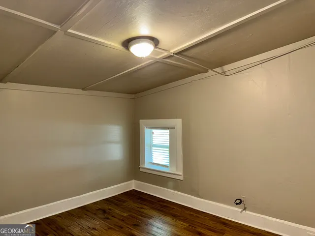 a view of room with window and wooden floor