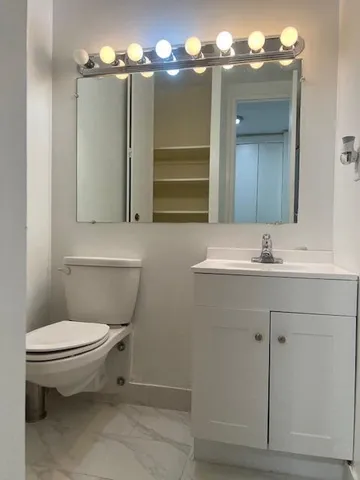 a bathroom with a toilet sink and mirror