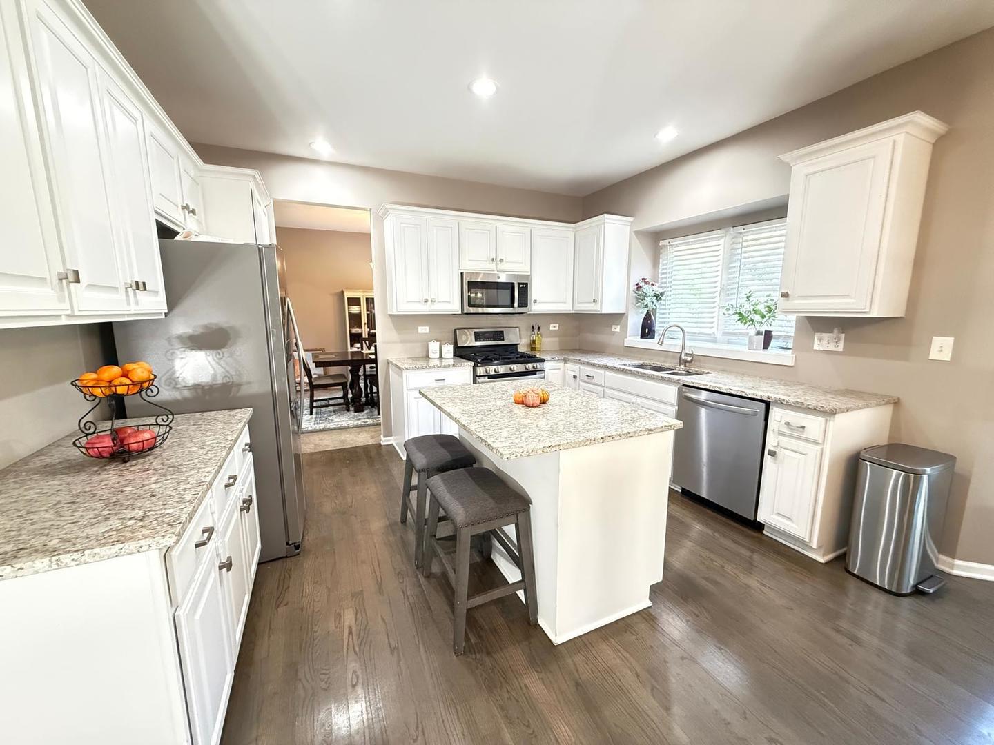 731 Lake Ridge Drive South Elgin, IL 60177 - Photo 6 of 28 a kitchen with stainless steel appliances granite countertop a refrigerator a stove top oven a sink dishwasher and white cabinets with wooden floor