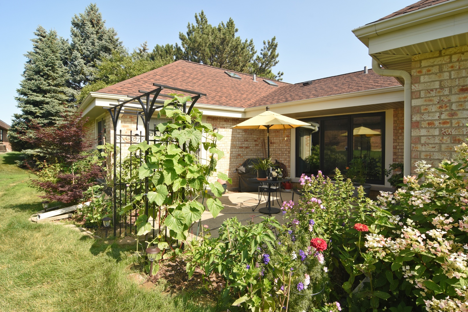 2305 Greenwood Road Northbrook, IL 60062 - Photo 24 of 25 a view of a white house with large windows and flower plants