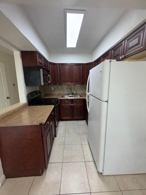 4654 Schall Road, Unit 4654 West Palm Beach, FL 33417 - Photo 4 of 11 a kitchen with stainless steel appliances a refrigerator sink and microwave