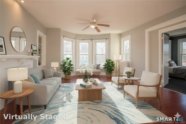 a living room with furniture a large window and a potted plant