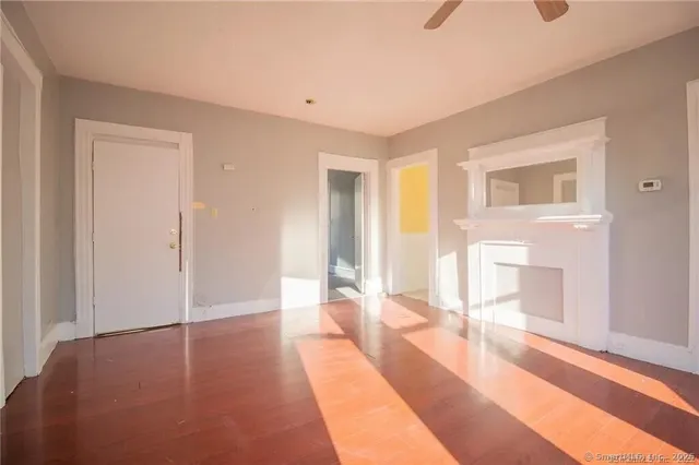 a view of a livingroom with wooden floor and a fireplace