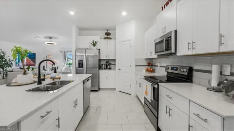 a kitchen with stainless steel appliances granite countertop a sink and white cabinets
