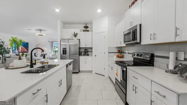 a kitchen with stainless steel appliances granite countertop a sink and white cabinets