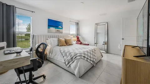 a bedroom with a bed a couch and a window