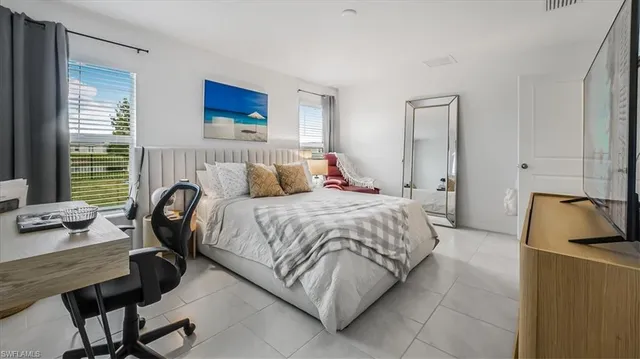 a bedroom with a bed a couch and a window