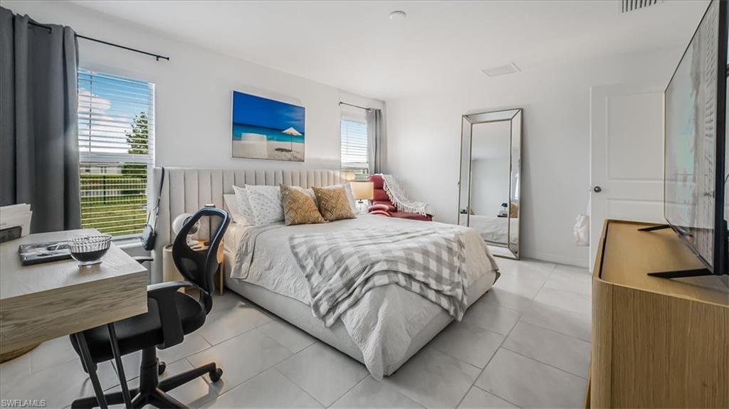 12252 Amber Waves Road Lehigh Acres, FL 33936 - Photo 15 of 35 a bedroom with a bed a couch and a window