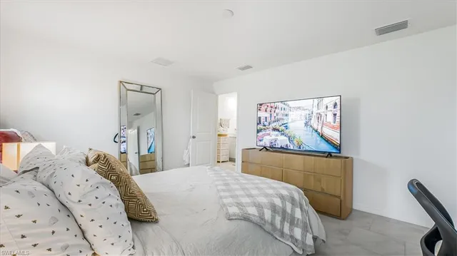 a bedroom with a bed and painting on the wall