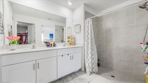 a bathroom with a shower sink and mirror