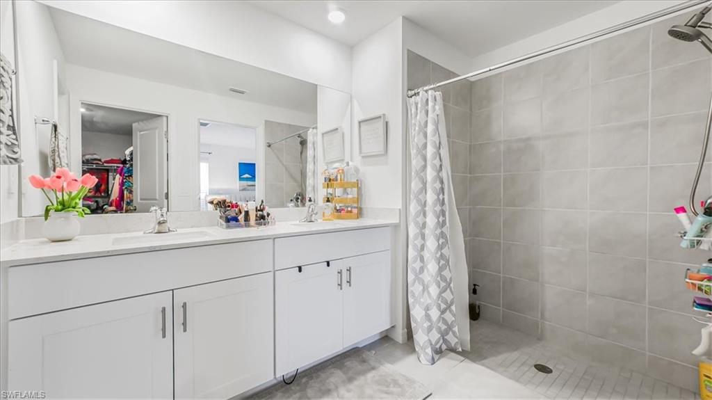 12252 Amber Waves Road Lehigh Acres, FL 33936 - Photo 19 of 35 a bathroom with a shower sink and mirror