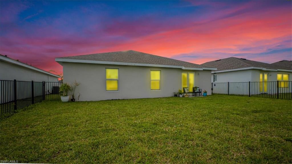 12252 Amber Waves Road Lehigh Acres, FL 33936 - Photo 2 of 35 a front view of a house with a garden