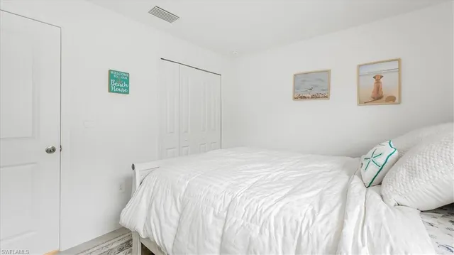 a bedroom with a bed and a white wall painting
