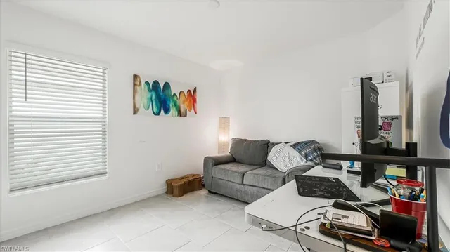 a living room with furniture a flat screen tv and a window