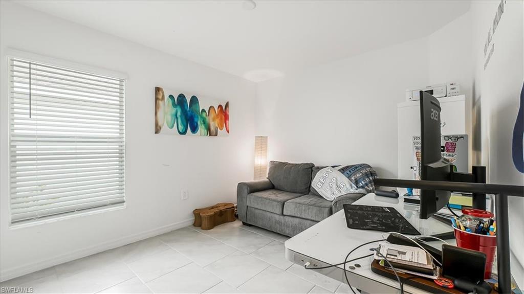 12252 Amber Waves Road Lehigh Acres, FL 33936 - Photo 23 of 35 a living room with furniture a flat screen tv and a window