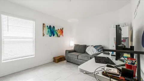 a living room with furniture a flat screen tv and a window