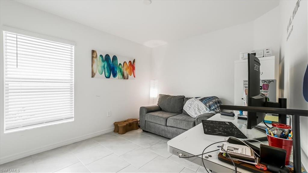 12252 Amber Waves Road Lehigh Acres, FL 33936 - Photo 24 of 35 a living room with furniture a flat screen tv and a window