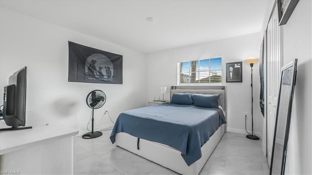 12252 Amber Waves Road Lehigh Acres, FL 33936 - Photo 27 of 35 a bedroom with a bed and a flat screen tv