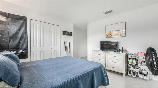 a bedroom with a bed and a television